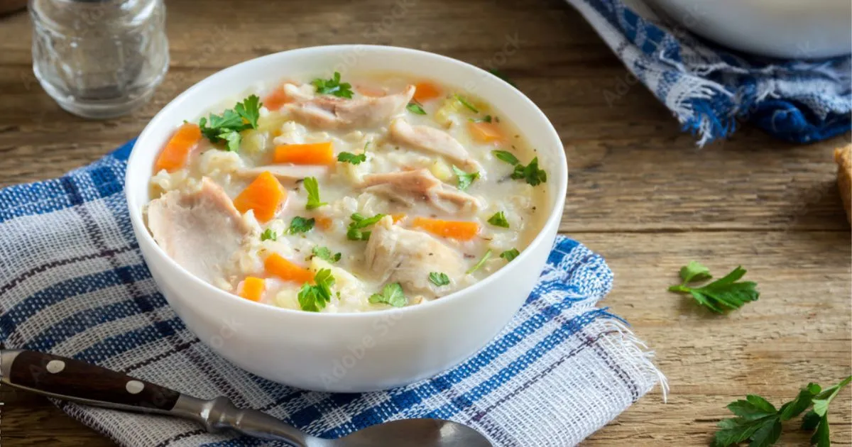 A warm bowl of Chicken and Rice Soup, with tender chicken pieces, cooked rice, and vegetables in a rich, flavorful broth.