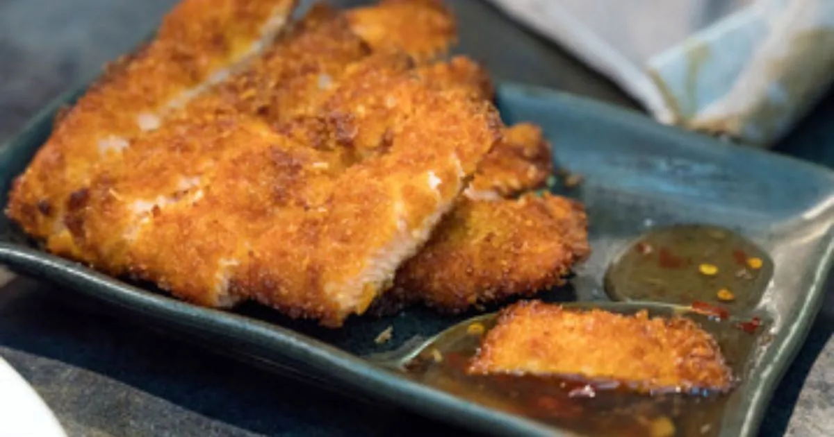 Perfectly cooked Air Fryer Salmon fillets with crispy edges and fresh herbs on top